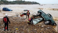 Tim penyelamat mencari seseorang yang terjebak di dalam mobil yang rusak terendam, menyusul banjir bandang di desa Agia Pelagia, di pulau Kreta. Seorang pria tewas dan seorang wanita hilang setelah mobil mereka hanyut dalam banjir bandang. Reuters/Stefanos Rapanis