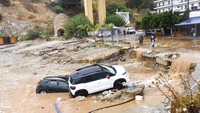 Dahsyatnya banjir bandang sampai menghanyutkan sejumlah mobil ke lautan. AP/Harry Nakos