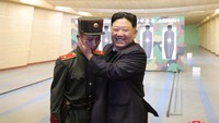 Ekspesi gembira Kim Jong Un saat menyapa salah satu taruna yang sedang berlatih menembak di Sekolah Revolusi Mangyongdae.   