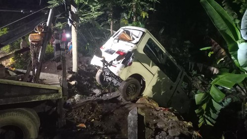 Polisi dan Petugas saat melakukan evakuasi terhadap mobil korban pada kecelakaan tunggal di Jembatan Sangket Sambangan, menggunakan mobil derek, Minggu (16/10/2022).