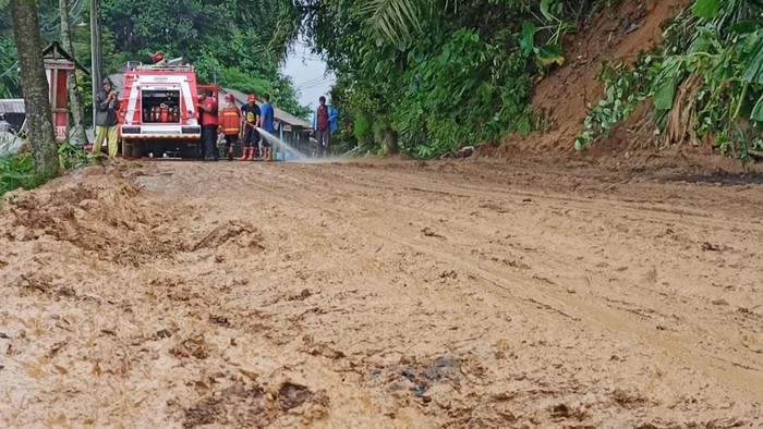 Proses pembersihan material longsor di jalur Penebel-Baturiti, tepatnya di Desa Bolangan, Kecamatan Penebel, Kabupaten Tabanan, Bali, dengan menggunakan bulldozer dan disemprot air pemadam kebakaran, Senin (17/9/2022).