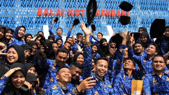 Sejumlah pegawai melempar peci usai disumpah menjadi PNS di Pemerintah Kota Kendari, Kendari, Sulawesi Tenggara, Senin (17/10/2022). Sebanyak 93 calon pegawai negeri sipil (CPNS) di lingkungan Pemerintah Kota Kendari diangkat dan diambil sumpah menjadi PNS. ANTARA FOTO/Jojon/aww.
