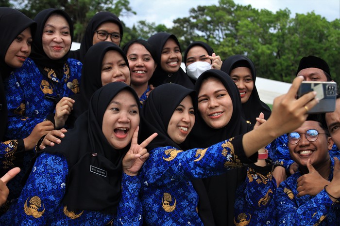 Sejumlah pegawai melempar peci usai disumpah menjadi PNS di Pemerintah Kota Kendari, Kendari, Sulawesi Tenggara, Senin (17/10/2022). Sebanyak 93 calon pegawai negeri sipil (CPNS) di lingkungan Pemerintah Kota Kendari diangkat dan diambil sumpah menjadi PNS. ANTARA FOTO/Jojon/aww.