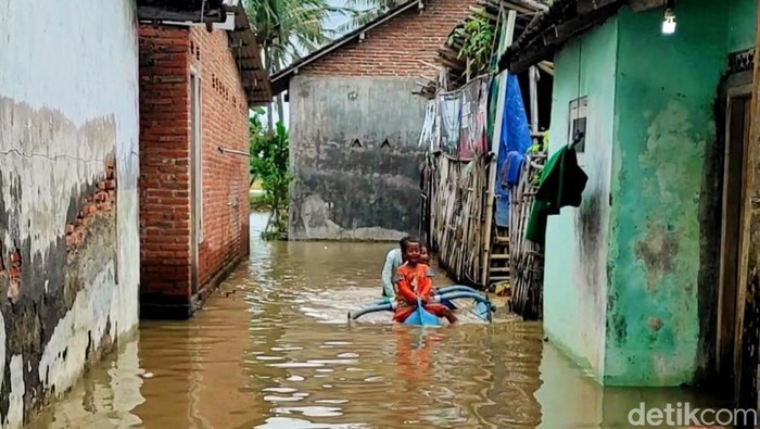 Anak-anak bermain di kampungnya yang terendam banjir di Banyuwangi