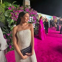 Eksis di karpet merah, Beby Tsabina bersandingan dengan para pesohor Hollywood. Pesona aktris keturunan Aceh ini terpancar maksimal dalam balutan gaun maksi putih strapless yang dipadu dengan clutch Chanel berwarna hitam. (Foto: Instagram/@bebytsabina)