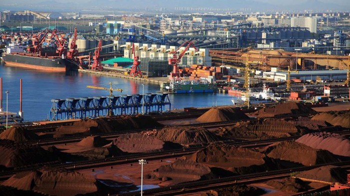 Biji besi dikumpulkan dengan cara ditumpul di Pelabuhan Rizhao, Shandong, Tiongkok, Senin (17/10/2022). Dari jauh terlihat bijih besi ini mirip padang pasir berwana hitam.