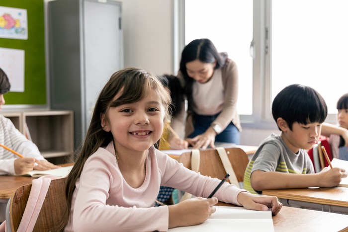 Portrait of Asian elementary school kids studying in a classroom. The girl smiled and looked at the camera. His classroom diversity