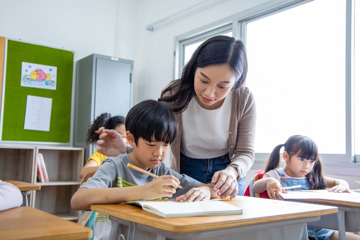 Portrait of Asian elementary school kids studying in a classroom. The girl smiled and looked at the camera. His classroom diversity