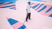 Seniman mural Adi Dharma atau dikenal sebagai Stereoflow berpose di atas karyanya, di Lapangan Taman Menteng, Jakarta Pusat, Selasa (18/10/2022).