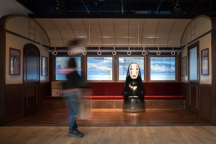 NAGAKUTE, JAPAN - OCTOBER 12: A guest attendee walks past Kaonashi or No-Face, an animation character from the film Spirited Away, that is copyrighted by Studio Ghibli, in the Ghiblis Grand Warehouse area during a preview for the Ghibli Park on October 12, 2022 in Nagakute, Japan. The theme park, which features Studio Ghibli animations, opens on November 1 in the Expo 2005 Aichi Commemorative Park. (Photo by Tomohiro Ohsumi/Getty Images)