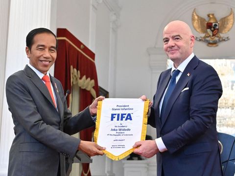 Presiden badan sepak bola dunia FIFA, Gianni Infantino (kanan) memberikan cinderamata kepada Presiden Indonesia Joko Widodo (kiri) usai memberikan keterangan pers hasil pertemuan mereka di Istana Merdeka di Jakarta, Indonesia, Selasa (18/10/2022). (Photo by ADEK BERRY/AFP via Getty Images)