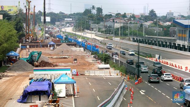 Sejumlah kendaraan melintas di samping proyek penanganan banjir di KM 8 Tol Pondok Aren-Serpong, Tangerang Selatan, Banten, Selasa (18/10/2022). Kementerian PUPR mengatakan tengah melakukan upaya untuk menangani banjir di Jalan Tol Pondok Aren-Serpong KM 8+500. (CNBC Indonesia/ Muhammad Sabki)