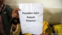 Pengunjung sidang tampak membawa poster.