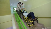 Petugas berlatih mengevakuasi pasien menuruni tangga.