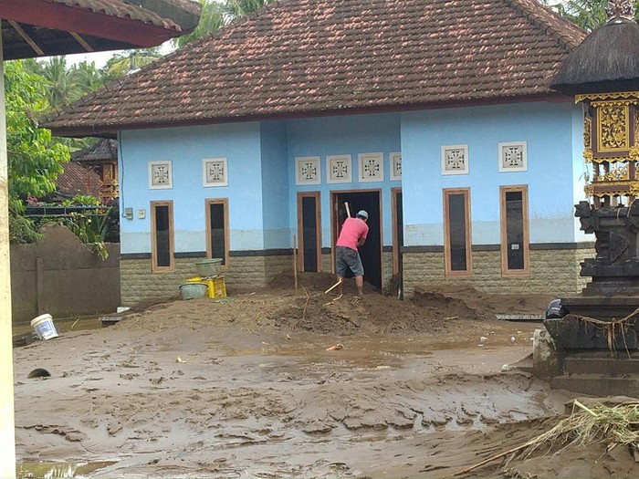 Warga membersihkan rumah dari lumpur akibat banjir bandang di Lingkungan Biluk Poh, Kelurahan Tegal Cangkring, Mendoyo, Jembrana, Bali, Selasa (18/10/2022). (I Ketut Suardika/detikBali)