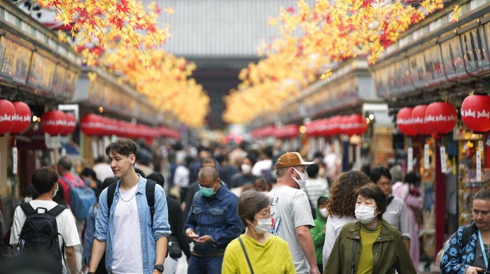 Turis melihat sekeliling saat mereka berjalan di kawasan Asakusa di Tokyo, Jepang, Senin (17/10/2022) waktu setempat. Kawasan Asakusa kembali ramai dikunjungi turis asing usai Jepang membuka perbatasan dan bebas visa.