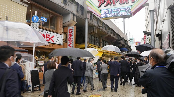 Foreign tourists take a rest over ice cream as they visit a promenade lined with souvenir shops leading to the Sensoji Buddhism temple in the famed Asakusa entertainment district of Tokyo, Monday, Oct. 17, 2022. (AP Photo/Hiro Komae)