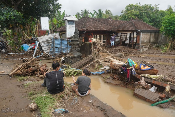 Dua warga mengumpulkan barang-barangnya setelah rumahnya sempat disapu banjir di Desa Tegal Cangkring, Jembrana, Bali, Selasa (18/10/2022). Banjir bandang akibat meluapnya Sungai Biluk Poh tersebut melanda empat kecamatan di Kabupaten Jembrana sehingga sedikitnya 45 unit rumah rusak dan sekitar 117 kepala keluarga mengungsi. ANTARA FOTO/Dicky Bisinglasi/nym.