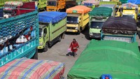 Warga melintas di dekat sejumlahl truk pengangkut sembako lintas Halmahera yang mogok beroperasi di Pelabuhan Ferry, Bastiong, Maluku Utara, Rabu (19/10/2022).
