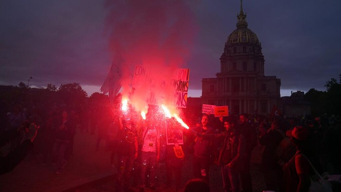 Buruh di Prancis Mogok Massal dan Tuntut Kenaikan Upah Akibat Inflasi Protestors hold flares during a demonstration for salary raise, in Paris, Tuesday, Oct. 18, 2022. Industries across France went on strike Tuesday to push for pay hikes that keep up with rising inflation, ramping up the clash between workers and the government after weeks of walkouts that hobbled oil refineries and sparked gasoline shortages around the country. (AP Photo/Francois Mori)