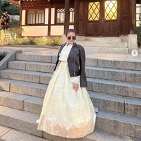 Postingan Instagram ibu Lisa BLACKPINK sontak jadi sorotan. Dalam penerbangannya ke Korea Selatan, dia tampil modis memakai baju tradisional Korea, Hanbok yang dipadukan dengan jaket kulit hitam. Foto: dok. Instagram @chitthipbruschweiler.