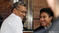 Dia tampak tersenyum dengan para pengacaranya.