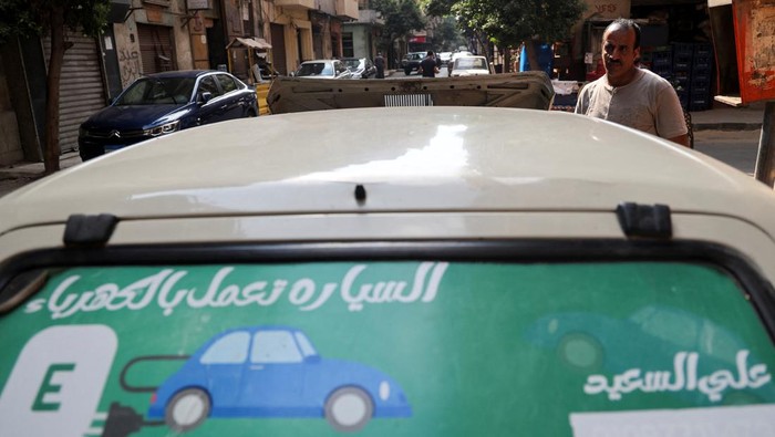 Ali al-Saeed, a 51-year-old an Egyptian teacher, poses for a photograph next to his 1985 Fiat-127 in front of his shop, after turning the car into an electric one to save fuel amid rising prices, resorting to a more environmental-friendly mode of transportation, in Cairo, Egypt October 12, 2022. REUTERS/Amr Abdallah Dalsh