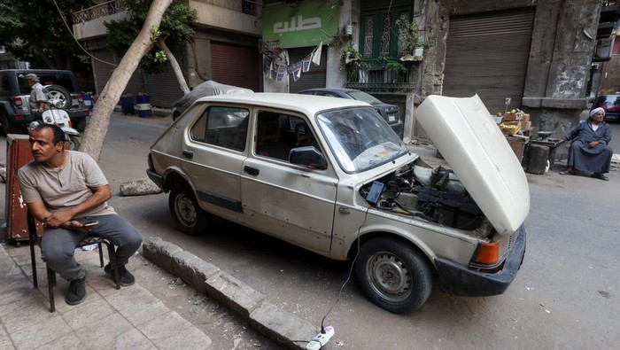 Kreatif, Guru di Mesir Ubah Mobil Bekas Jadi Kendaraan Listrik Ali al-Saeed, a 51-year-old an Egyptian teacher, poses for a photograph next to his 1985 Fiat-127 in front of his shop, after turning the car into an electric one to save fuel amid rising prices, resorting to a more environmental-friendly mode of transportation, in Cairo, Egypt October 12, 2022. REUTERS/Amr Abdallah Dalsh