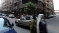 Ali al-Saeed saat berkendara dengan Fiat listrik modifikasinya di jalan raya Kota Kairo, Mesir.