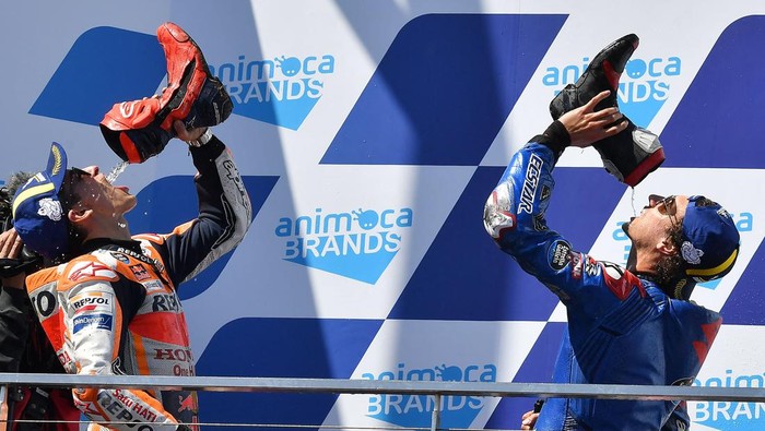 Suzuki Ecstars Spanish rider Alex Rins (R) and second placed Repsol Hondas Spanish rider Marc Marquez drink from their driving boots on the podium after the MotoGP Australian Grand Prix at Phillip Island on October 16, 2022. - -- IMAGE RESTRICTED TO EDITORIAL USE - STRICTLY NO COMMERCIAL USE -- (Photo by Paul CROCK / AFP) / -- IMAGE RESTRICTED TO EDITORIAL USE - STRICTLY NO COMMERCIAL USE -- (Photo by PAUL CROCK/AFP via Getty Images)