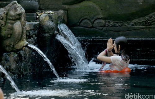 Ilustrasi Melukat di Pura Tirta Empul, Bali.