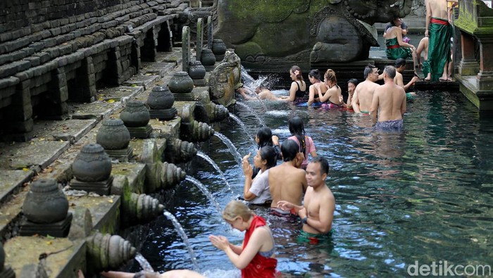 Ilustrasi orang Melukat di Pura Tirta Empul, Bali.
