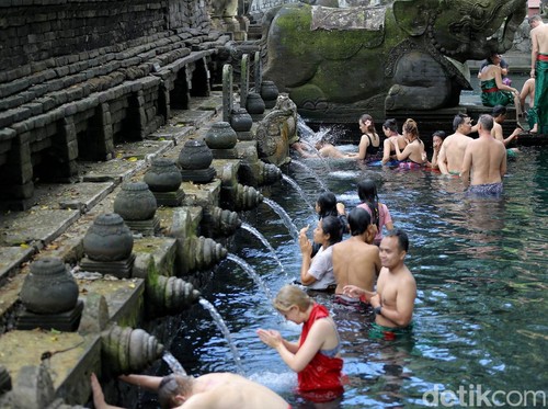 Ilustrasi orang Melukat di Pura Tirta Empul, Bali.