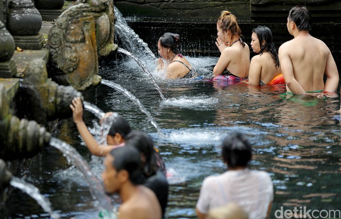 Ilustrasi orang Melukat di Pura Tirta Empul, Bali.