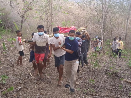 Pihak keluarga dibantu warga dan petugas saat mengevakuasi jasad Korban Benyamin Basfain