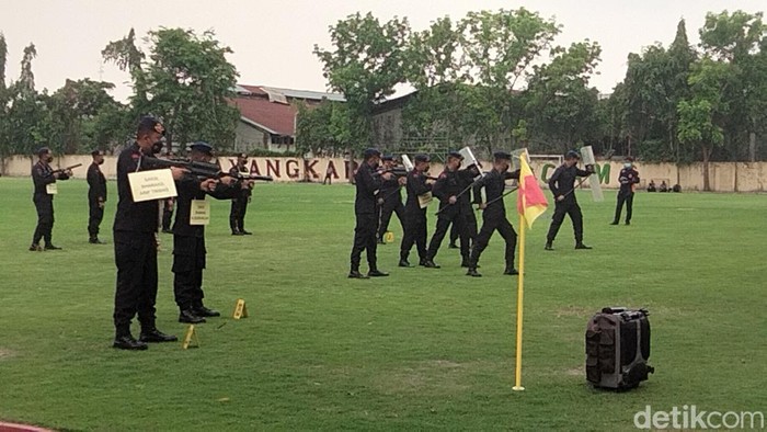 Personel Brimob memperagakan penembakan gas air mata saat rekonstruksi Tragedi Kanjuruhan di Mapolda Jatim