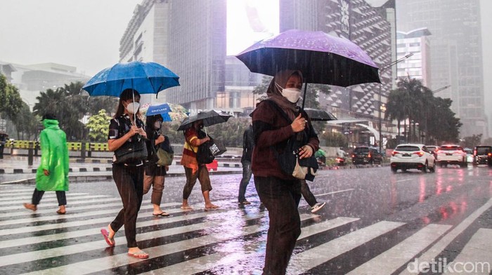 Potret Warga Basah-basahan Terobos Hujan di Pelican Crossing Tosari Warga menggunakan payung basah-basahan menerobos hujan saat melintas di pelican crossing Tosari, Jakarta Pusat, Rabu (19/10/2022). Hujan deras yang mengguyur pada saat jam pulang kerja membuat para pegawai menerobos hujan untuk menggunakan kendaraan umum. Musim penghujan yang datang lebih awal diperkirakan masih berjalan panjang dan mencapai puncaknya pada Desember 2022 hingga Januari 2023.