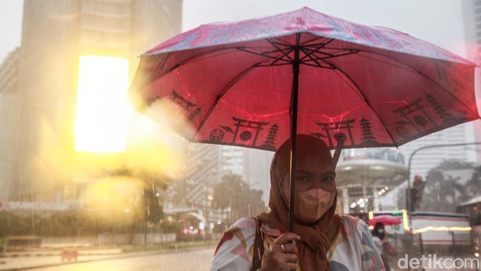 Potret Warga Basah-basahan Terobos Hujan di Pelican Crossing Tosari Warga menggunakan payung basah-basahan menerobos hujan saat melintas di pelican crossing Tosari, Jakarta Pusat, Rabu (19/10/2022). Hujan deras yang mengguyur pada saat jam pulang kerja membuat para pegawai menerobos hujan untuk menggunakan kendaraan umum. Musim penghujan yang datang lebih awal diperkirakan masih berjalan panjang dan mencapai puncaknya pada Desember 2022 hingga Januari 2023.