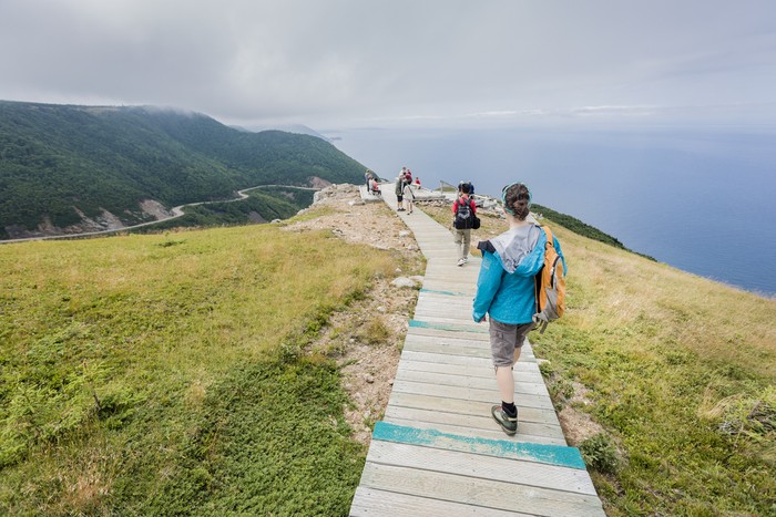 Pulau Cape Breton, Kanada Cape Breton Highlands National Park, Nova Scotia, Canada - July 19, 2012: Tourists and hikers enjoying the view of the Skyline trail, one of the most popular hike of the Cape Breton Highlands National park in Nova Scotia. The hiking trails are located around the Cabot Trail that circles the Cape Breton peninsula.
