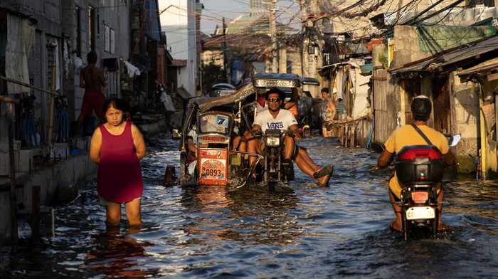 Saat Bentor Jadi Andalan Warga Filipina Menerjang Banjir, Begini Potretnya Motorcycle taxis, modified to cope with flooding, ride at coastal town of Hagonoy, Bulacan province, Philippines, October 3, 2022. REUTERS/Eloisa Lopez