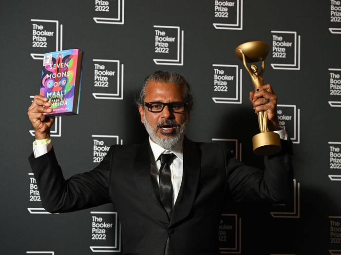LONDON, ENGLAND - OCTOBER 17: Camilla, Queen Consort presents winner Shehan Karunatilaka for The Seven Moons of Maali Almeida with the Booker Prize for Fiction 2022 award at the Roundhouse, on October 17, 2022, in London, England. (Photo by Toby Melville - WPA Pool/Getty Images)