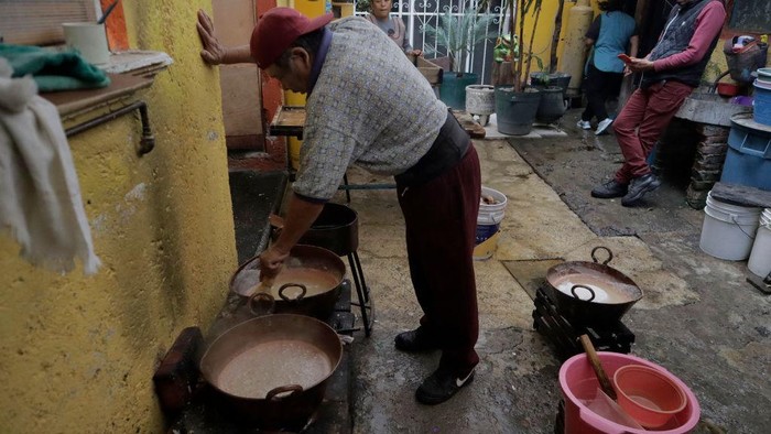 Unik, Gula di Meksiko Ini Berbentuk Tengkorak Tukang Pedro MejΓa memasak larutan gula dalam panci tembaga untuk membuat tengkorak gula di sebuah rumah di Xochimilco, Mexico City, Selasa (18/10/2022).
