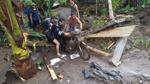 Warga Desa Jungutan, Karangasem, mengevakuasi sepeda motor yang sempat tertimbun akibat hujan deras, Rabu (19/10/2022). (Foto: I Wayan Selamat Juniasa/detikBali)