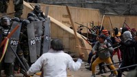 Mereka berdemo untuk memperjuangkan hak atas tanah mereka. Warga tampak memukuli polisi dengan tongkat.