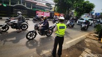 Petugas kepolisian berjaga mengatur arus lalu lintaa di Jalan Ampera Raya.