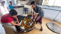 Pekerja mengeluarkan rak daging Mandi dari oven di sebuah restoran di Sanaa, Yaman. Mandi perlu dimasak di bawah tanah. Terkadang daging untuk Mandi dimasak di oven meja, tapi rasa dan kualitasnya tidak sama dengan yang dikubur.