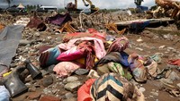 Barang-barang milik warga yang berserakan di jalanan akibat tersapu oleh banjir. Tampak barang yang tersapu tersebut terdiri dari bantal dan juga kain.