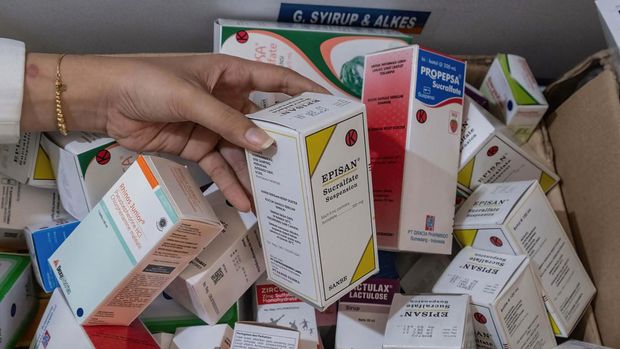 KENDARI, SOUTH EAST SULAWESI, INDONESIA - 2022/10/20: A pharmacist unloads a line of syrup-type drugs from a sales shelf at a pharmacy. Ministry of Health gave instructions not to give or temporarily prescribe drugs over-the-counter in the form of syrup to the public due to atypical cases of progressive acute kidney failure is occurring in children in Indonesia. (Photo by Andry Denisah/SOPA Images/LightRocket via Getty Images)