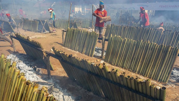 Sejumlah warga membakar Inuyu atau nasi bambu khas daerah setempat di arena Festival Danau Poso (FDP) di Tentena, Kabupaten Poso, Sulawesi Tengah, Jumat (21/10/2022). Pembakaran Inuyu massal sebanyak 7.000 ruas bambu yang menghabiskan 3,5 ton beras ketan dan 2.100 butir kelapa itu berhasil memecahkan rekor pembakaran nasi bambu terbanyak setelah sebelumnya dilakukan di Minahasa, Sulawesi Utara sebanyak 6.000 ruas dan dicatatkan dalam Musium Rekor Indonesia (MURI). ANTARA FOTO/Basri Marzuki/hp.