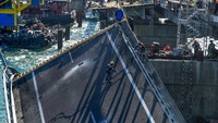 Pekerja membongkar bagian yang rusak dari sambungan Jembatan Krimea di Rusia, Kamis (20/10/2022).